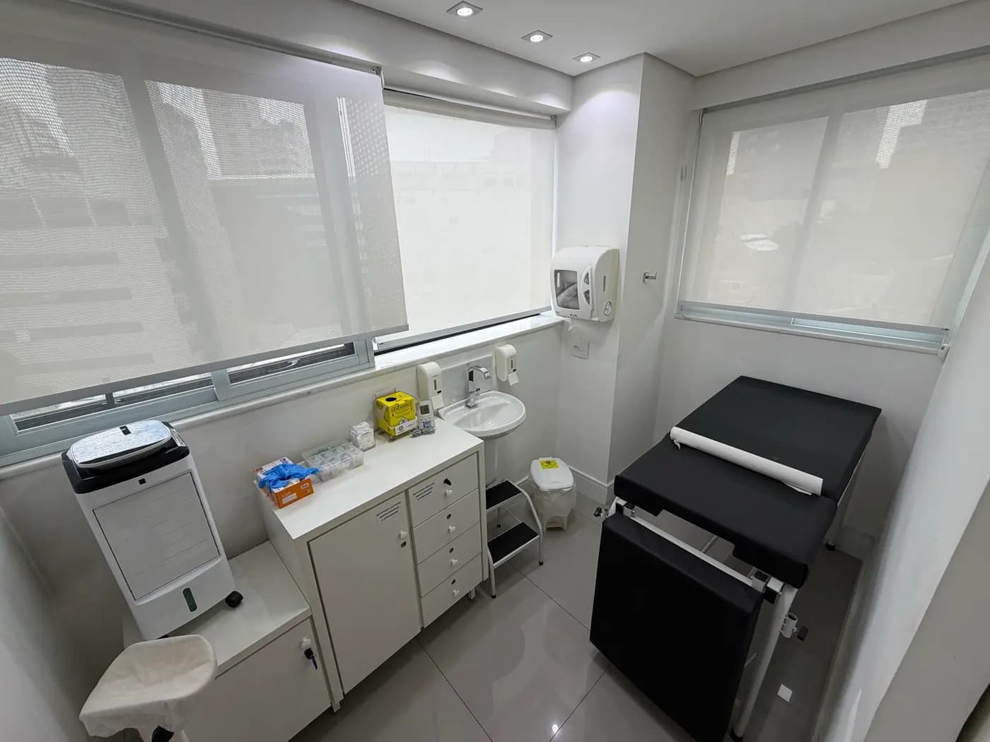 Sala de exames, com maca, bancada e pia