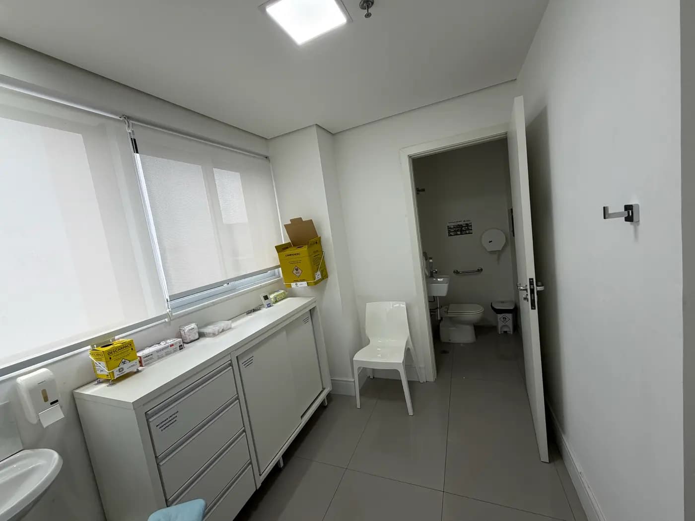 Sala de apoio, com bancada e banheiro adaptado ao lado
